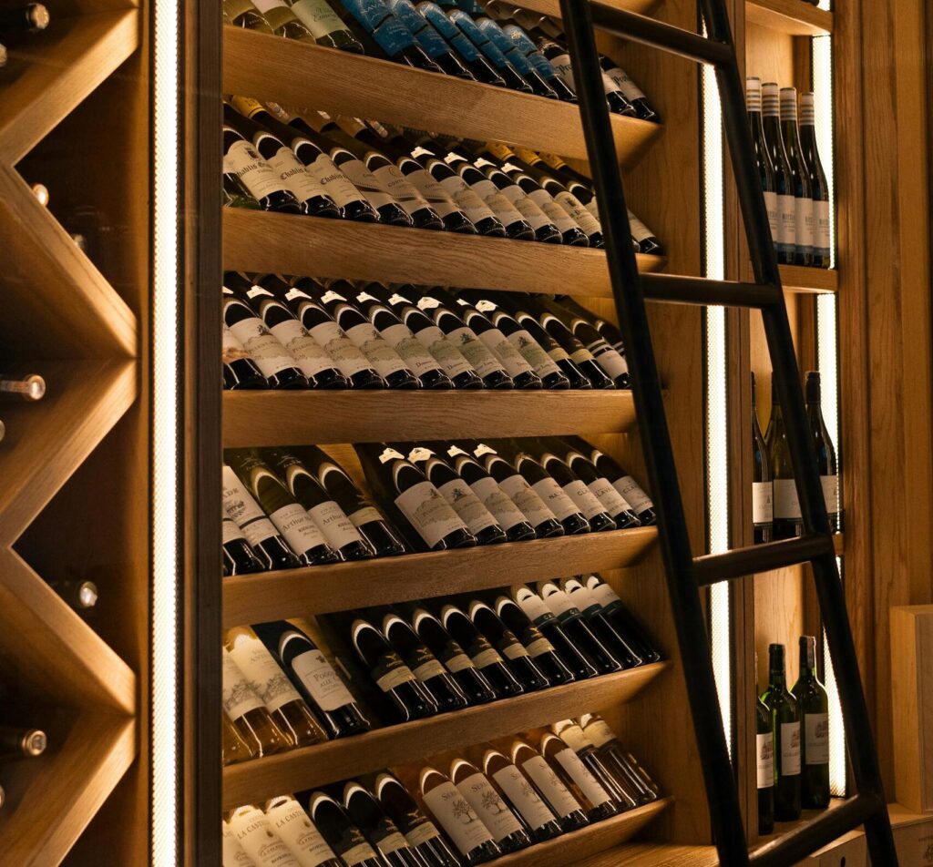 Elegant wine cellar with diverse bottles on wooden shelves in Baku.